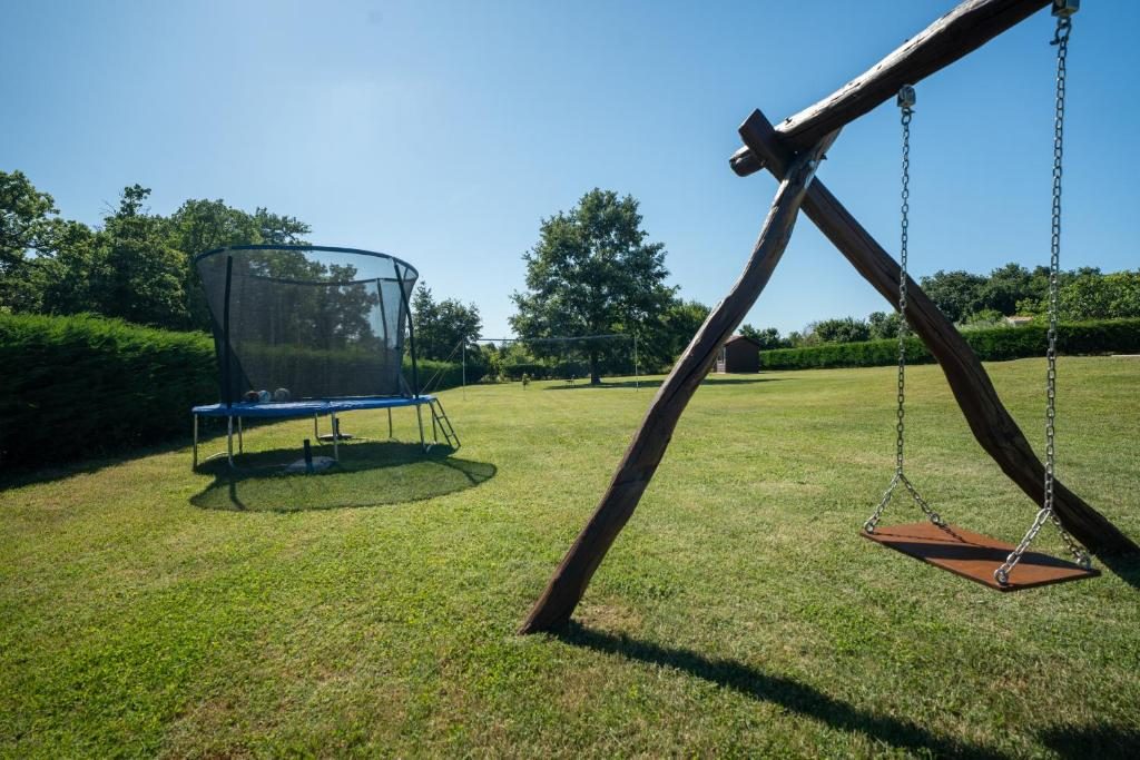 Drvena ljuljačka i trampolin na travnjaku Ville Elide